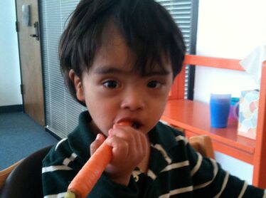Client/child eating a carrot and working on oral-motor skills