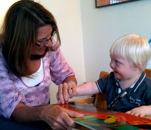 Margaret using a book to work with a young child on language development